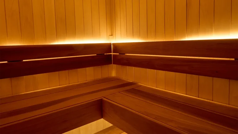 The corner of a sauna that's warmly lit. Discover the heart benefits of sauna at WOW