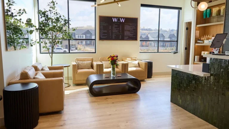 The lobby of a wellness clinic, featuring comfy seating and a decorated coffee table.