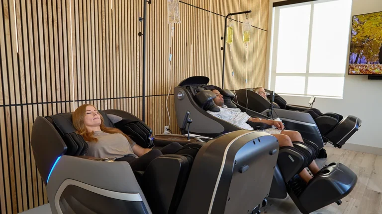 3 clients sit in massage chairs during IV Therapy at WOW Clinic